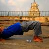 A man practices yoga in the Lal Bagh Botanical Garden (Kempegowda tower in the background)