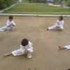 Students performing stretching exercise during yellow belt test