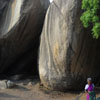 A old woman standing near the big rocks at Mamallapuram