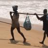 Two fishermen carry their net at Marina in Chennai...