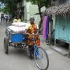 A woman pushes a tricycle overloaded with cement bags at Perambur - Chennai