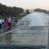 People walking along through water fountains