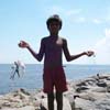 A young boy standing on a rock  at Tuticorin beach